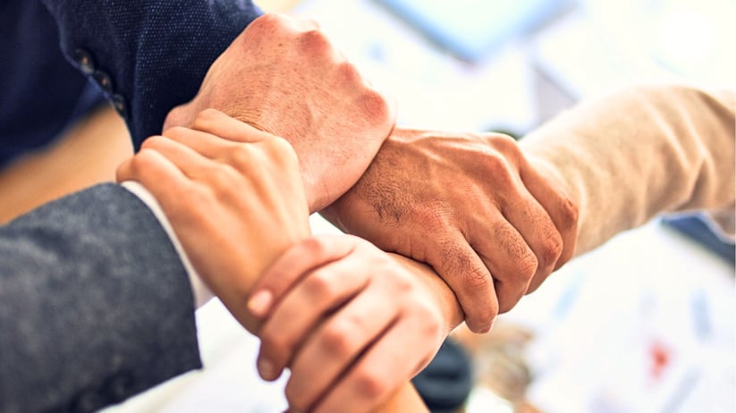 Four people holding hands.